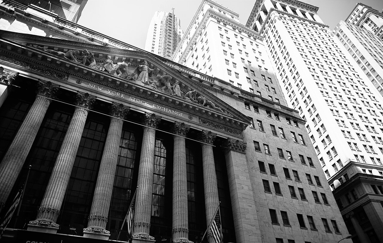 ภาพขาวดำด้านหน้าอาคาร New York Stock Exchange และอาคารสูงในย่านการเงินนิวยอร์ก